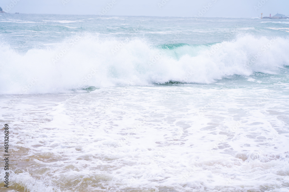 Waves crashing onto a sandy beach.