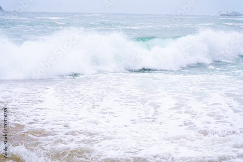 Waves crashing onto a sandy beach.