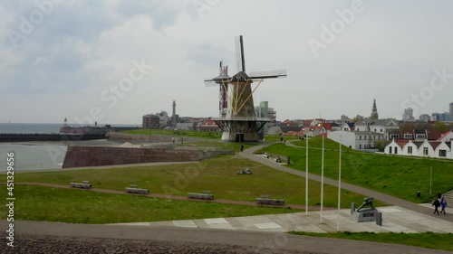 Aerial orbit over the waterfront buildings with Oranjemolen windmill and Het Arsenaal tower in Vlissingen, the Netherlands photo