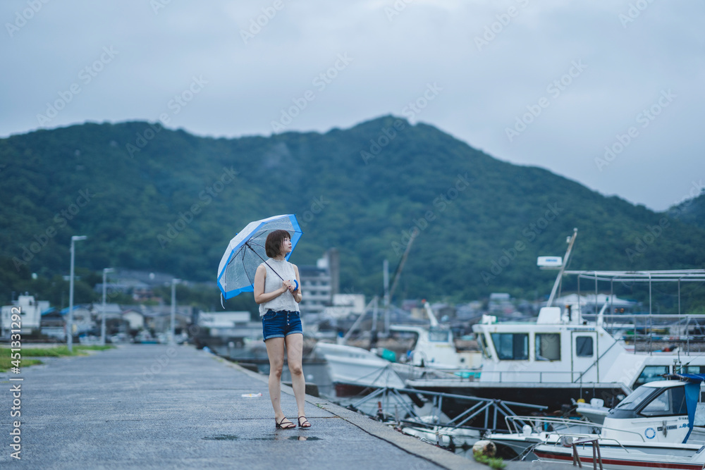 雨の日の海にいる女性