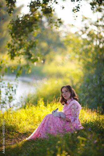 Quadro su tela beautiful girl in a vintage rose dress walks by the lake with a white fluffy rab