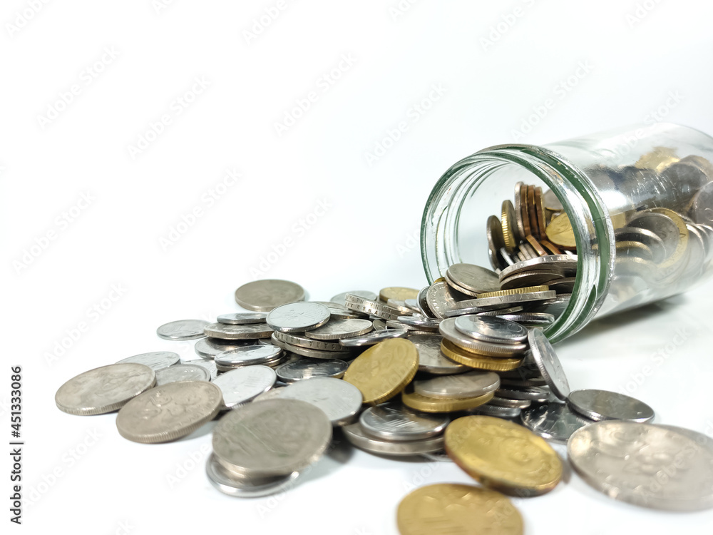 Business and Saving concept.Glass jar with coins isolated on white background with copy and text space. Business and Saving concept.Glass jar with coins isolated on white background with copy and text space.