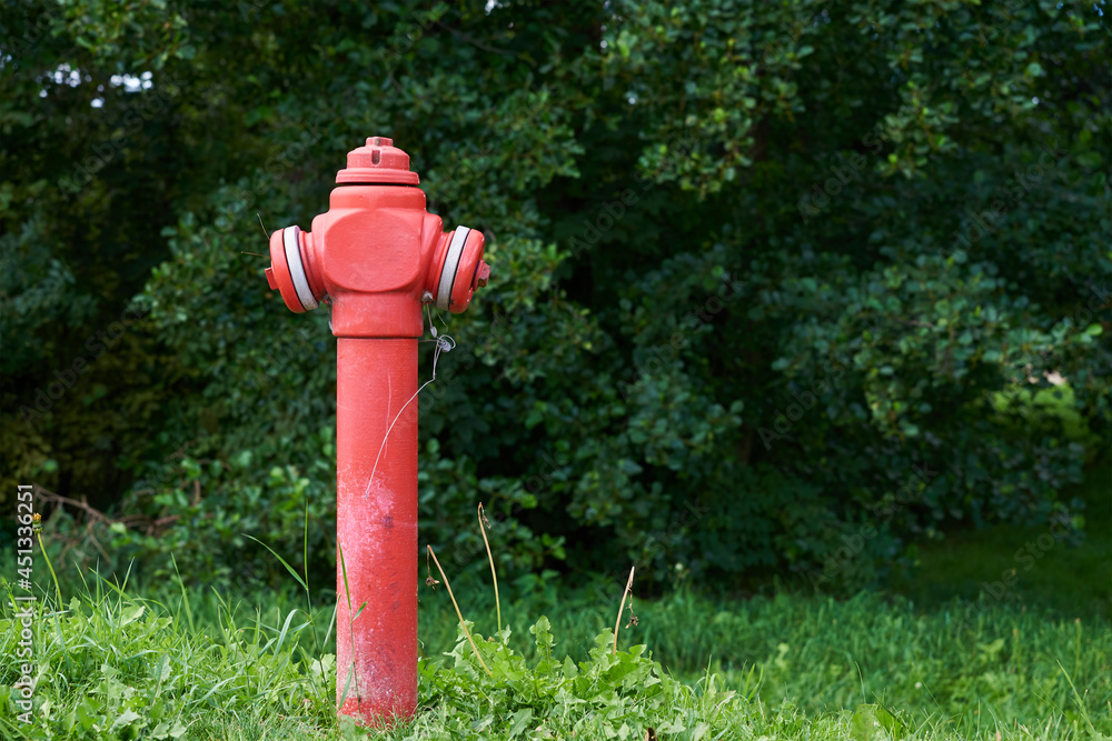 Red fire hydrant in city park, close up. Preventive measures against urban fires Red fire hydrant in city park, close up. Preventive measures against urban fires