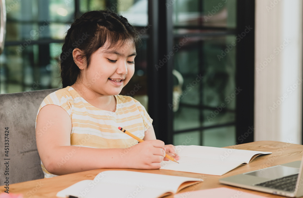 A asian child girl in a good mood is studying at home. A asian child girl in a good mood is studying at home.