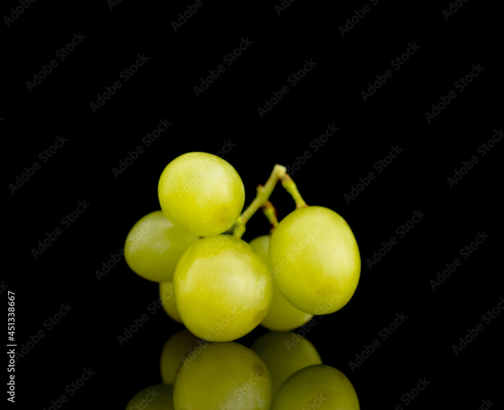 Several berries of sweet juicy grapes, close-up, isolated on black.