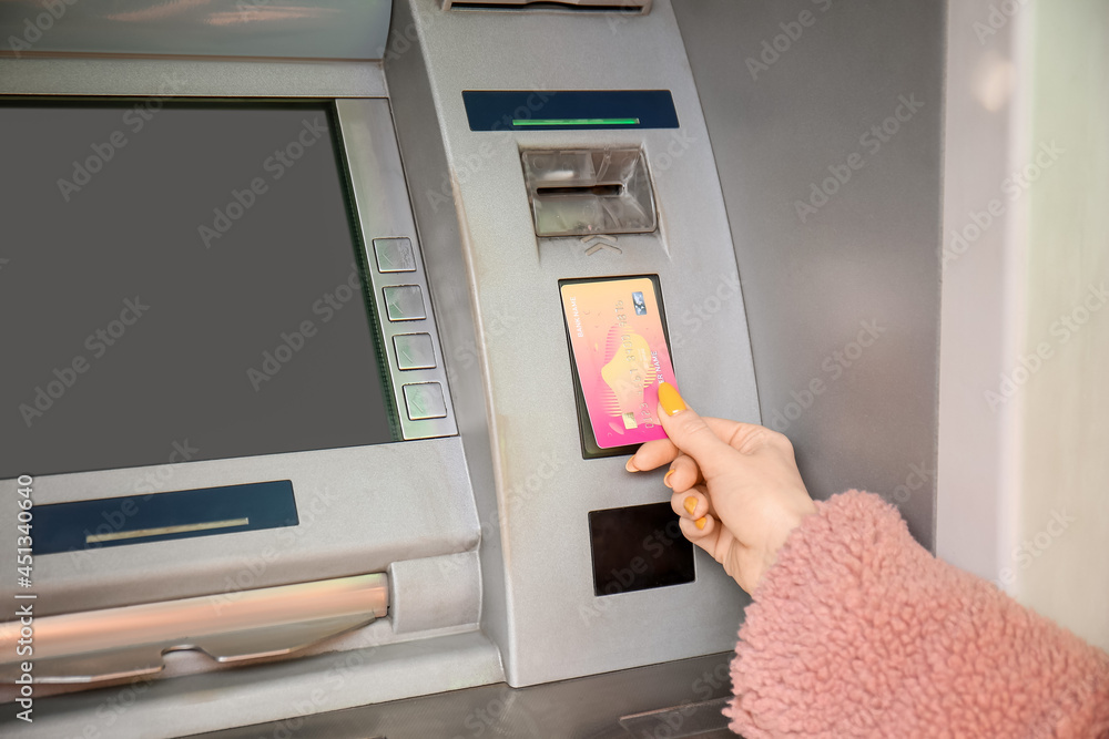 Young woman using ATM, closeup Young woman using ATM, closeup