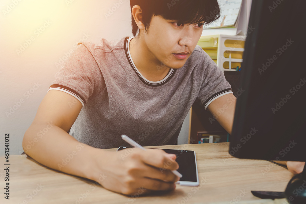 young business man using tablet while reading an e-mail on laptop on his desk at office young business man using tablet while reading an e-mail on laptop on his desk at office