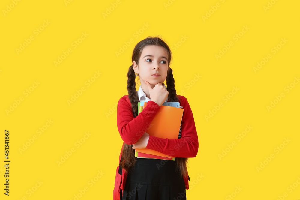 Thoughtful little school girl on color background Thoughtful little school girl on color background