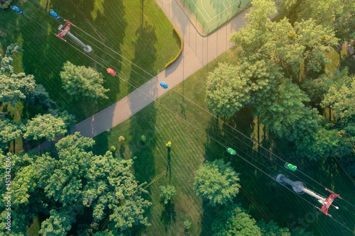Morning in the park: summer park with lawns, grass, paths, trees and cable car. Drone aerial view.