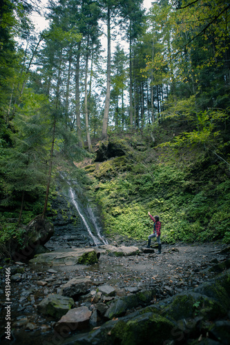 young hiking woman looking at waterfall