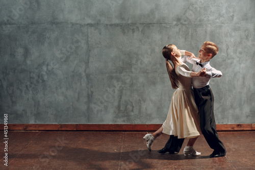 Photo Young boy and girl dancing in ballroom dance Viennese Waltz.