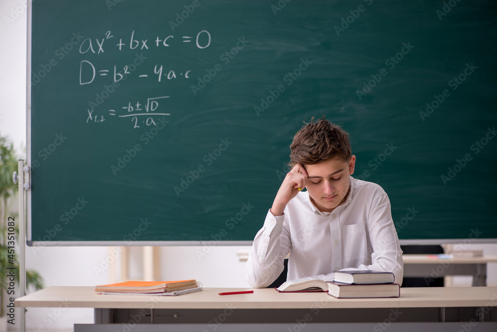 Schoolboy studying math in front of blackboard Schoolboy studying math in front of blackboard