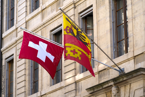 Swiss flag and flag of City and Canton Geneva at the old town of Geneva on a sunny summer morning. Photo taken July 29th, 2021, Geneva, Switzerland.