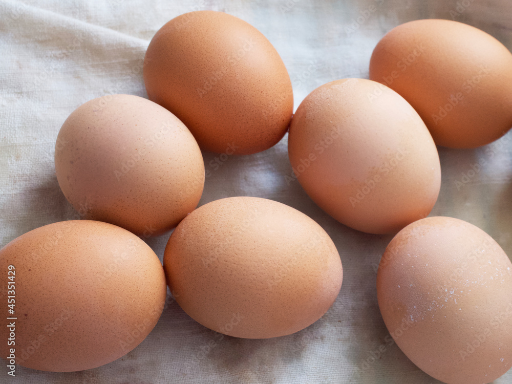 Chicken eggs lie on a fabric surface, close-up. Multi-colored chicken eggs. Chicken eggs lie on a fabric surface, close-up. Multi-colored chicken eggs.