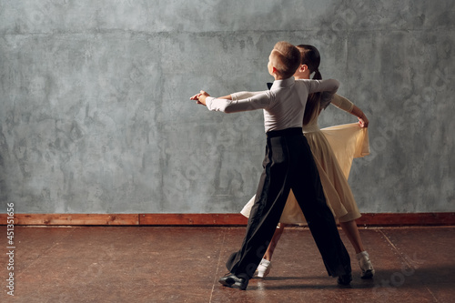 Young boy and girl dancing ballroom dance Viennese Waltz.
