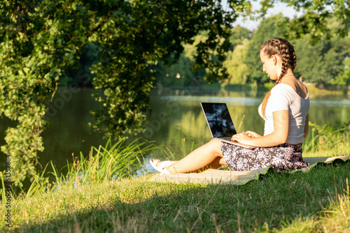 Outdoor online business technology. Student girl work with laptop tablet, computer in nature outside. Person woman sitting in summer park with people. Happy hipster young distance learning concept.