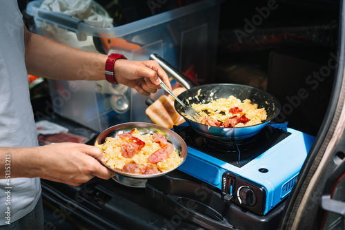 Cuadro en lienzo Person cooking omelet on camping stove