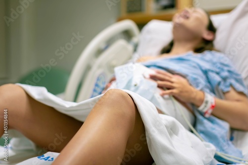 Фотография A woman in labor, with painful contractions, lying in the hospital bed