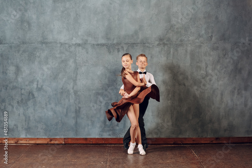 Young dancers boy and girl dancing in ballroom dance Samba. © primipil