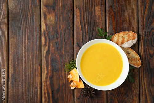 Concept of tasty food with pumpkin soup on wooden table