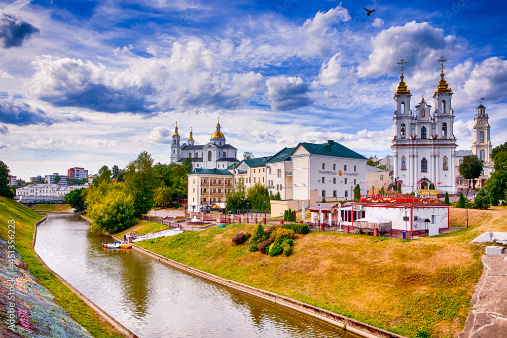 Obraz premium Vitebsk, Belarus - August 1, 2021: Vitebsk City Skyline with Resurrection Church, Holly Assumption Cathedral and Town Hall Across The Vitba River in Vitebsk, August 1, 2021