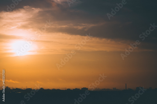 High resolution photo of morning sky with sun in clouds over city