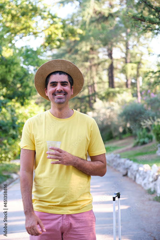 Obraz premium Tourist drinking a refreshment, standing and looking at camera.