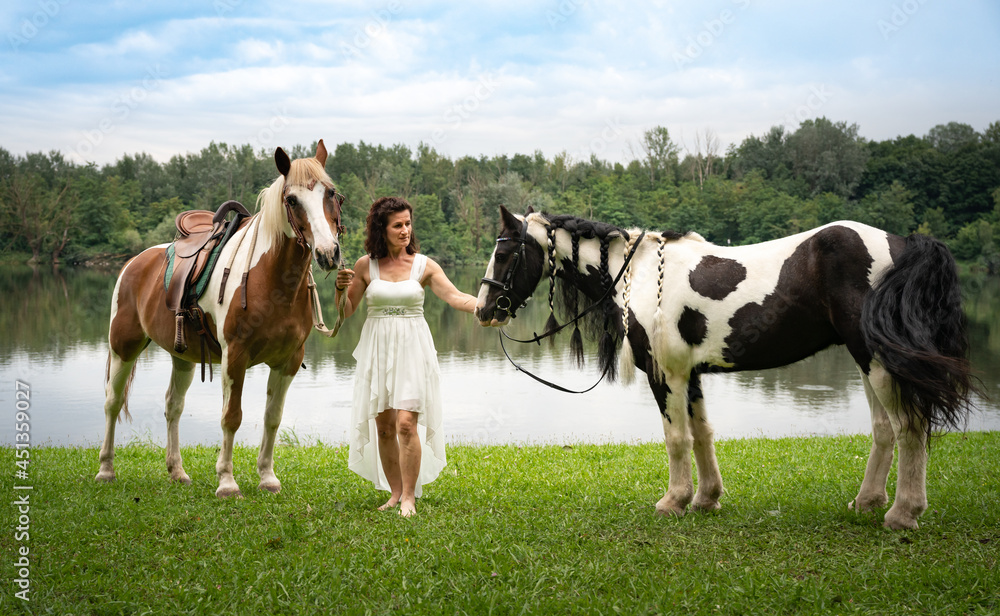 Frau im Ballkleid mit zwei Pferden