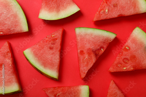 Ripe juicy watermelon slices on red background