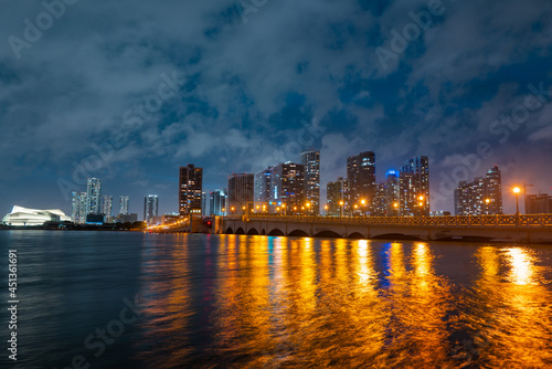 Miami, Florida cityscape skyline on Biscayne Bay. Panorama at dusk with urban skyscrapers and bridge over sea with reflection. © Volodymyr