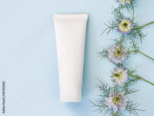 Принти на полотні Unbranded white squeeze bottle cosmetic cream tube and line frame border of blue Nigella flowers on pastel blue background