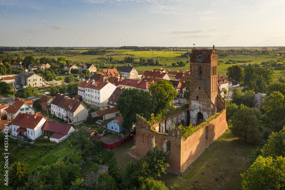 Aerial: The restored facades of the Zheleznodorozhny town on the background of an abandoned old Prussian church
