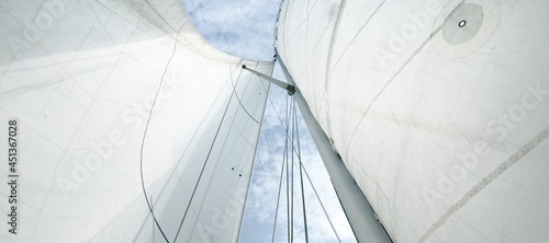White sloop rigged yacht sails against clear blue sky with cirrus clouds. Gulf of Finland photo