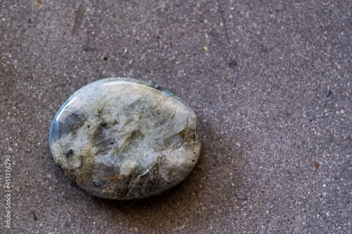 Pierre roulée polie galet de labradorite sur un fond noir - Minéral naturel photo