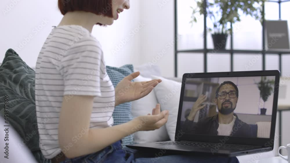 Young woman using laptop for video conference with male friend at home. Discussing project online. Remote communication of happy young people. Working from modern home office during pandemic. Young woman using laptop for video conference with male friend at home. Discussing project online. Remote communication of happy young people. Working from modern home office during pandemic.