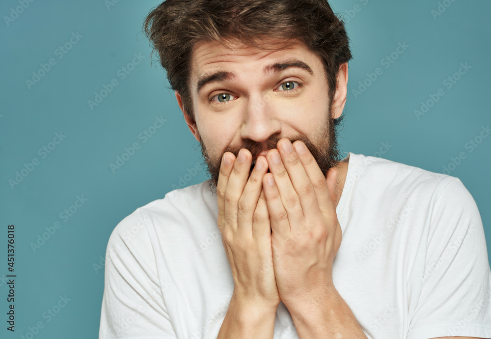 Man in a white t-shirt hand gestures anger blue background Man in a white t-shirt hand gestures anger blue background