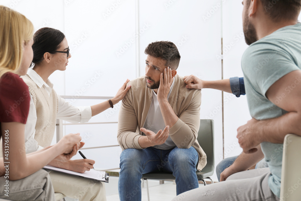 Psychotherapist working with group of drug addicted people at therapy session indoors Psychotherapist working with group of drug addicted people at therapy session indoors