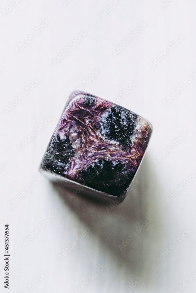 Pierre roulée polie cube de charoïte sur un fond blanc - Minéral naturel Pierre roulée polie cube de charoïte sur un fond blanc - Minéral naturel