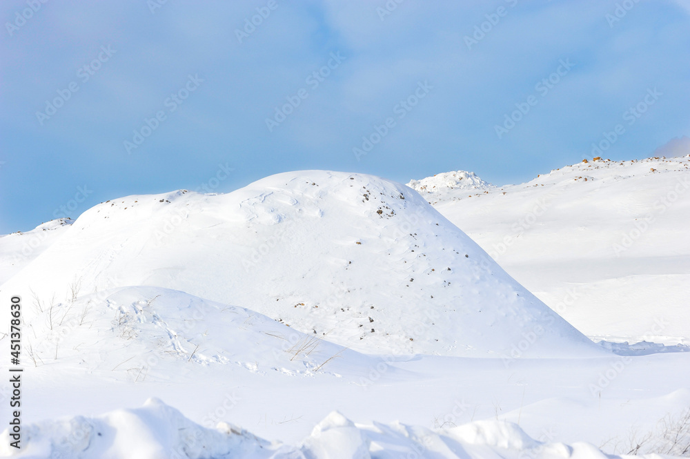 Beautiful winter landscape with a huge drifts of snow, sparkling in the bright sun on blue sky background. Winter background. Frosty sunny day.Arctic, cold climate.