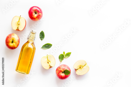 Foto Apple cider vinegar in a bottle with fresh apples
