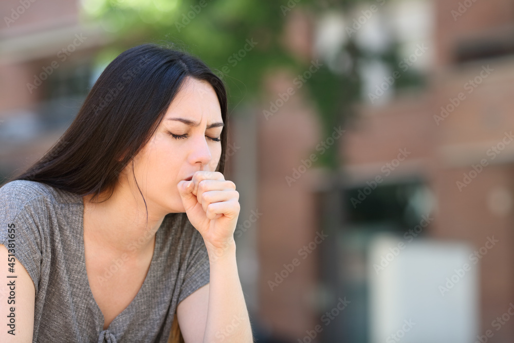 Asian woman coughing in the street Asian woman coughing in the street