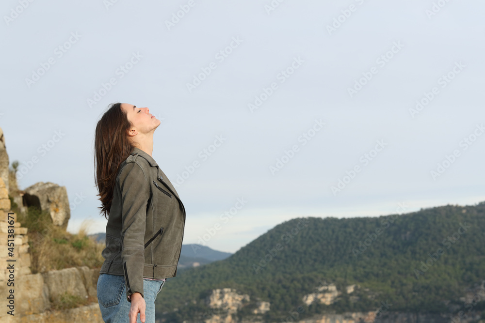 Casual woman breathing fresh air in the mountain