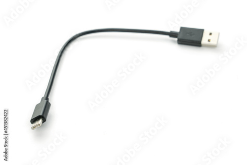 Black USB cable with plugs type A and type C at edges on white background. Soft selective focus. For Mobile charger and Transfer data