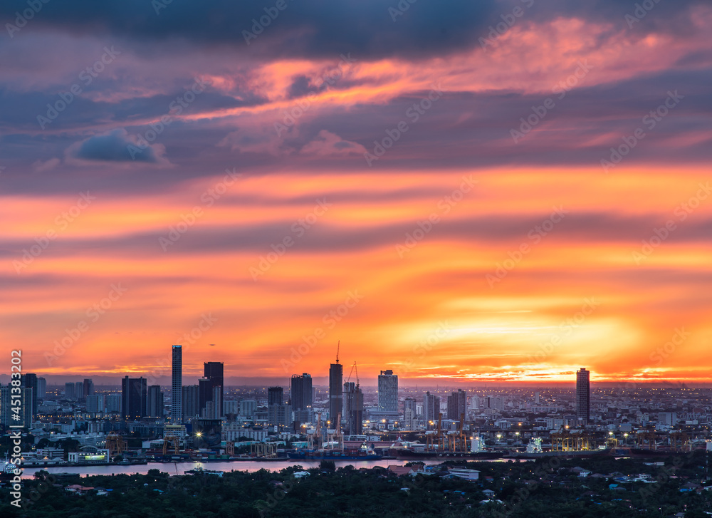 Gorgeous panorama scenic of the sunrise with cloud on the orange sky over large metropolitan city in Bangkok. Copy space, Selective focus.
