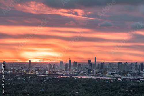 Gorgeous panorama scenic of the sunrise with cloud on the orange sky over large metropolitan city in Bangkok. Copy space, Selective focus.