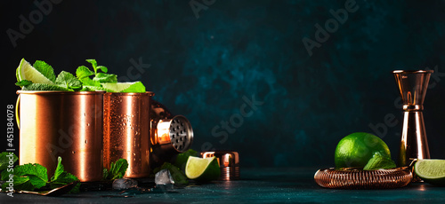 Photography Moscow mule cocktail in copper mug with lime, ice, ginger beer, vodka and mint