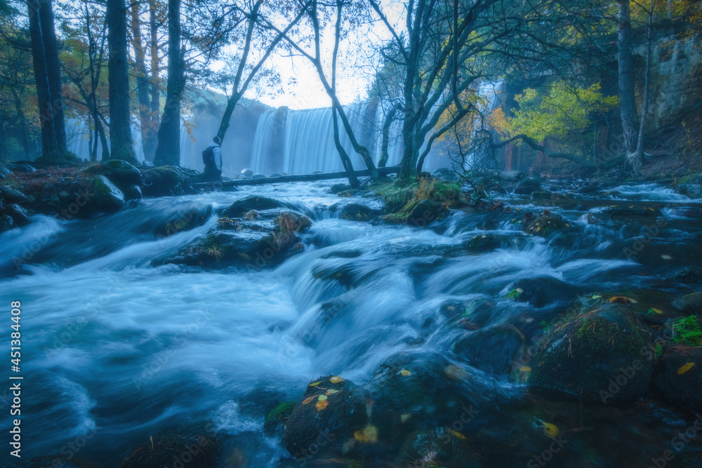 River waterfall landscape in autumn forest with orange and yellowish leaves of the trees at Guadarrama national park, Lozoya river, Spain River waterfall landscape in autumn forest with orange and yellowish leaves of the trees at Guadarrama national park, Lozoya river, Spain