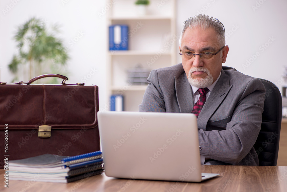 Old male employee working in the office Old male employee working in the office