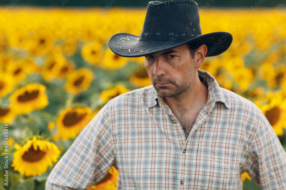 Man farmer standing in a sunflower field