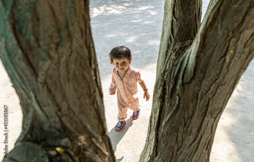 portrait of cute indian baby girl playing in the park.